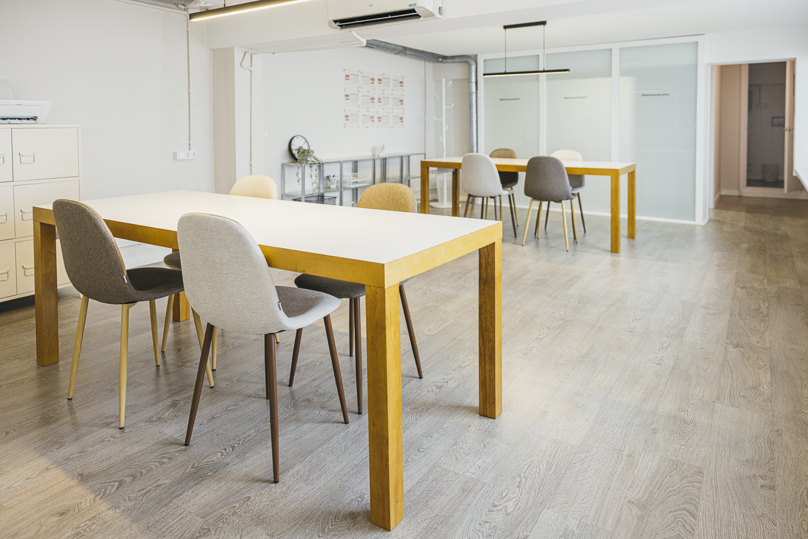 Sala de coworking amb taules de fusta i cadires